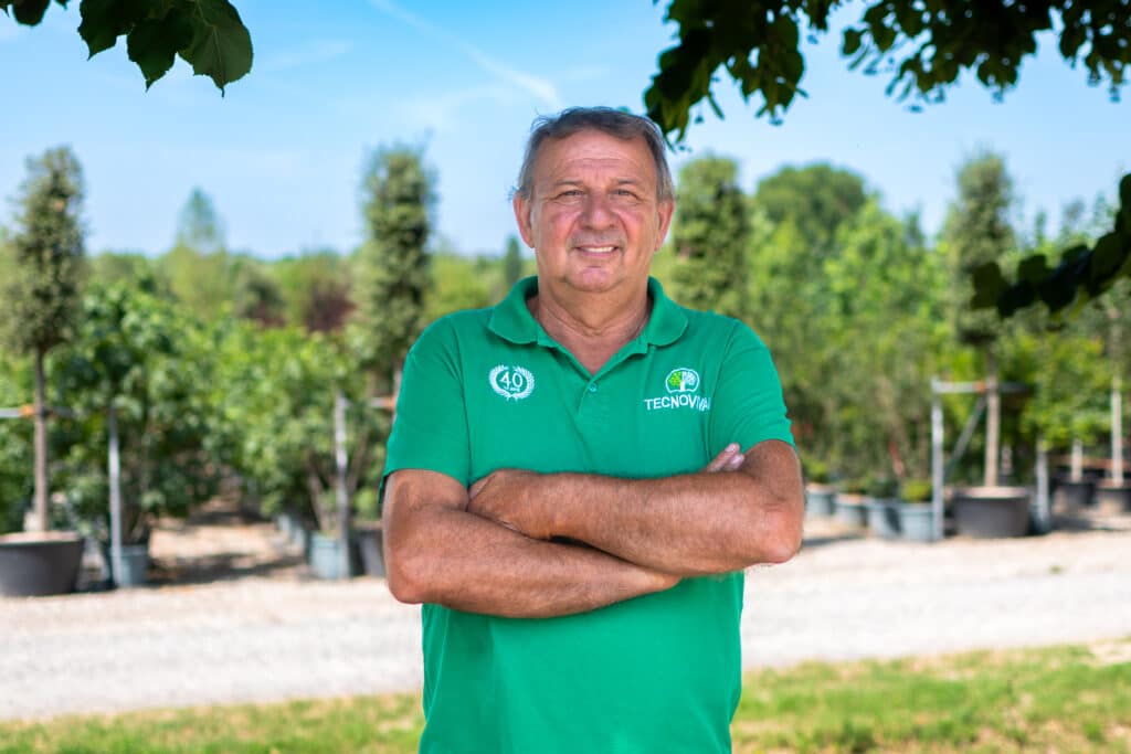 Membro del team TECNOVIVAI ritratto nel vivaio di Canneto sull'Oglio (MN), tra gli alberi in contenitore.